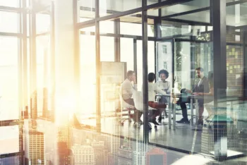 Multiple exposure shot of a businesspeople having a meeting superimposed over a cityscape